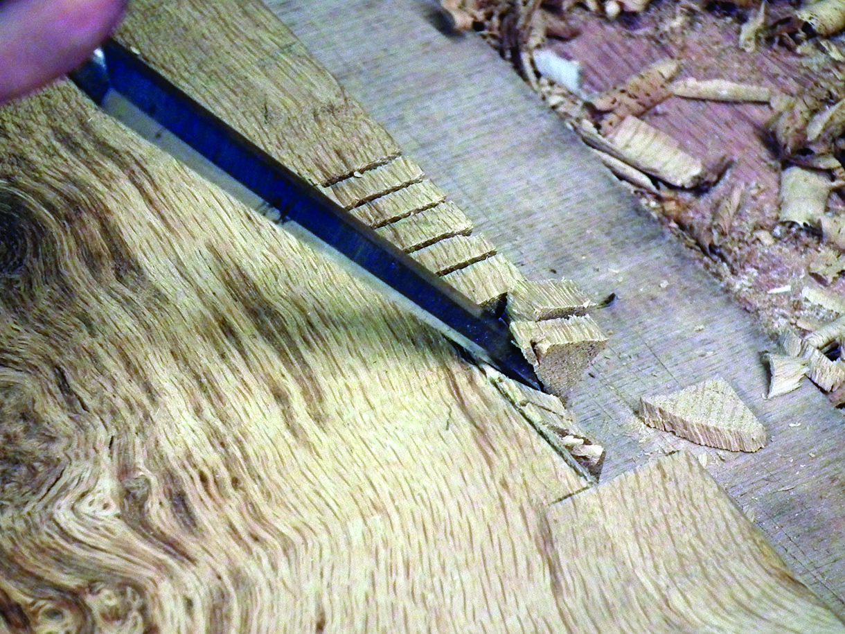 The rebate for the legs on the seat board being cut. The relief cuts and final chisel work can be seen on the waste piece.
