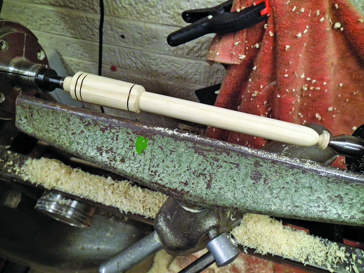 The pivot pin being turned on the lathe.