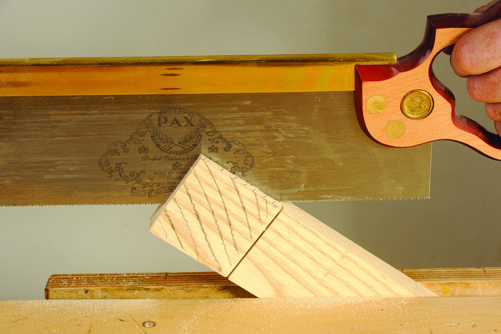 cutting down the grain of a piece of wood with a hand saw