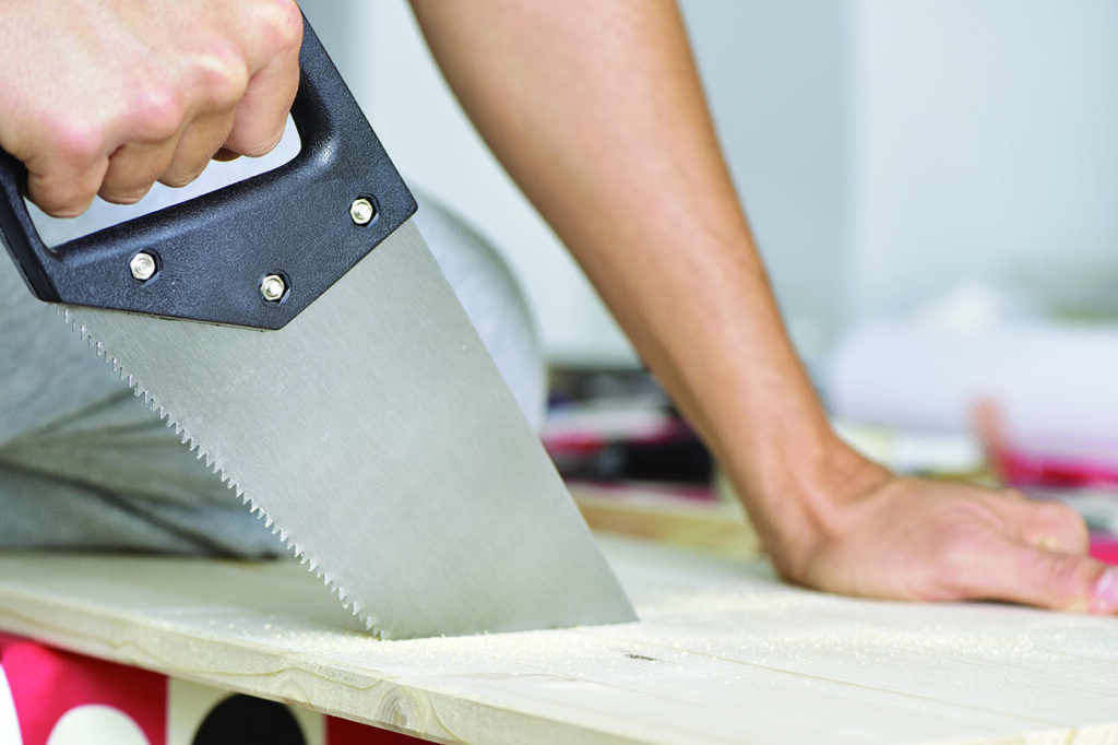 Cutting through a plank of wood with a hand saw