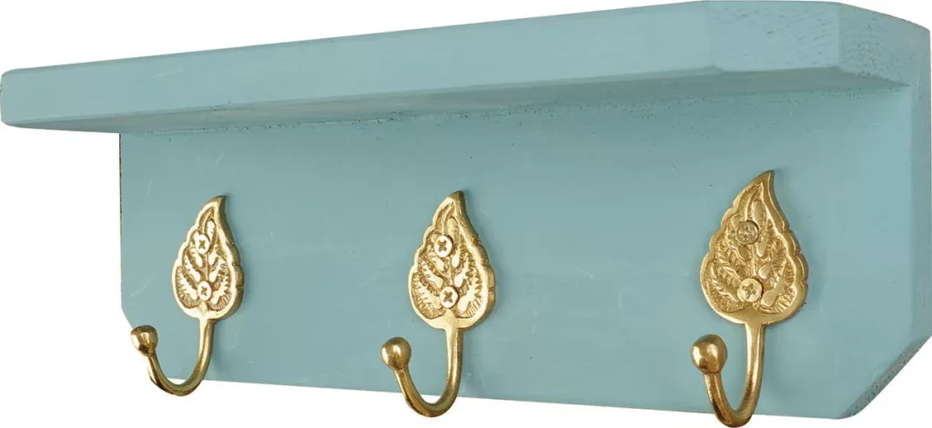 Aqua shelf with three gold decorative hooks.