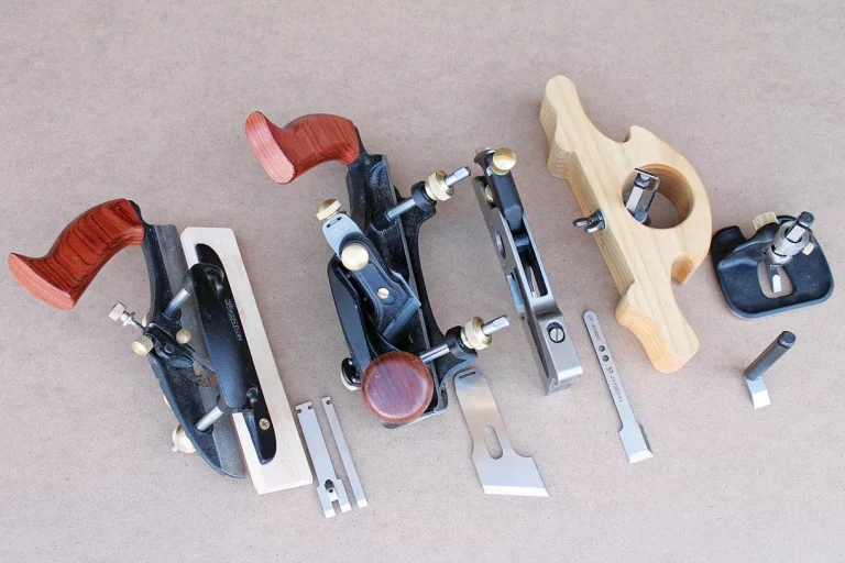 Assorted woodworking hand planes and blades on a table.