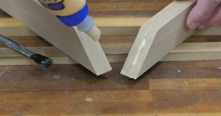 Applying wood glue to wooden pieces before joining.
