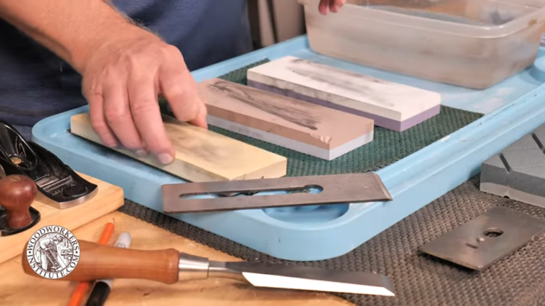 Sharpening woodworking tools with whetstones on a workbench.