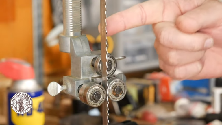 Adjusting bandsaw blade guides for precision cutting.