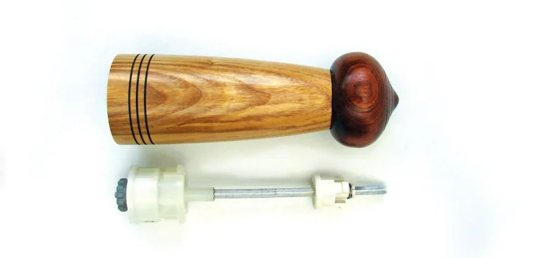 Wooden pepper mill with internal grinder mechanism.