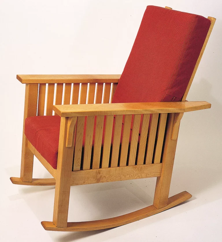 Wooden rocking chair with red cushions.