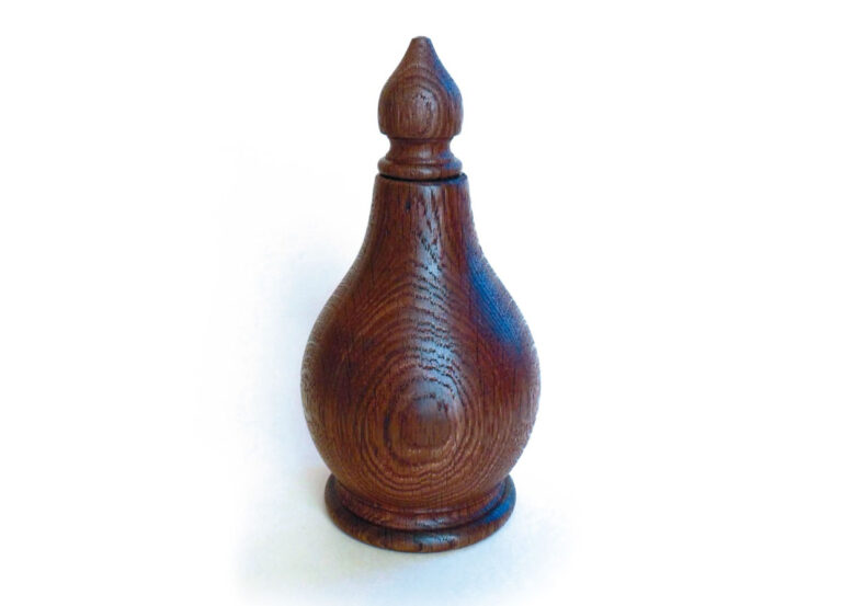 Wooden chess piece, shaped like a pawn.