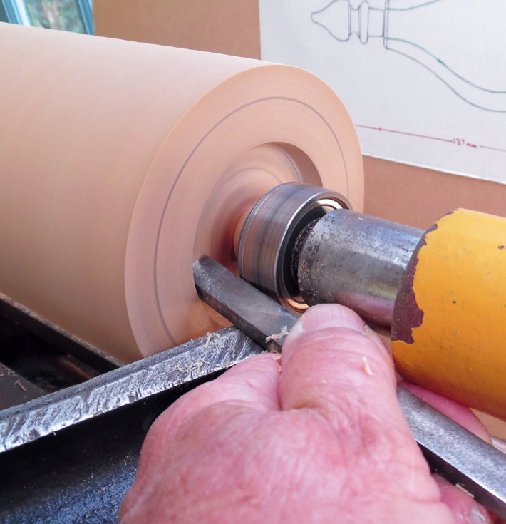 Woodturning a cylindrical object using a lathe.