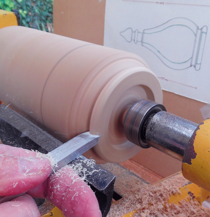 Woodturning on lathe with chisel tool.