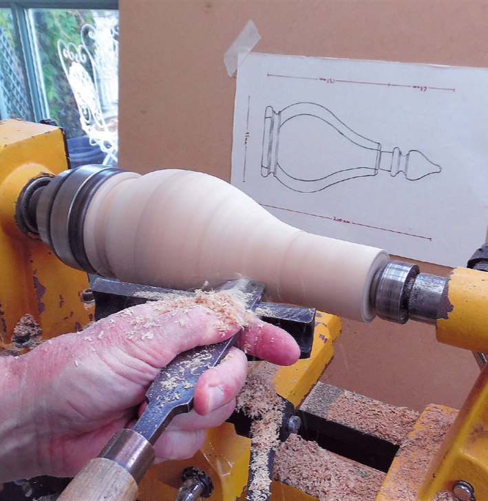 Woodturning on lathe with woodworking blueprint.
