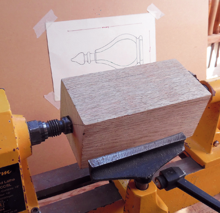 Wood lathe setup with blueprint drawing behind.