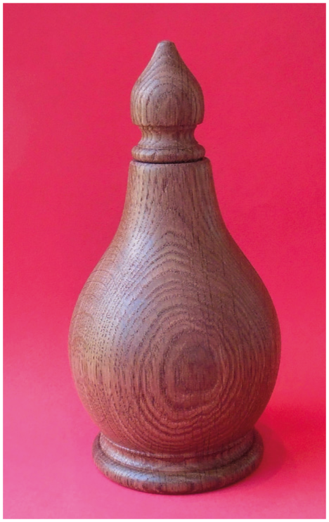 Wooden urn with pointed lid, red background.