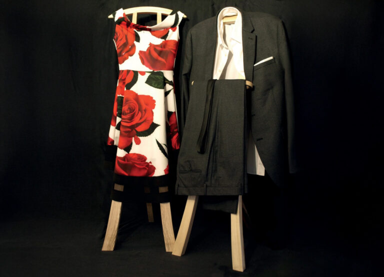 Elegant dress and suit on hangers