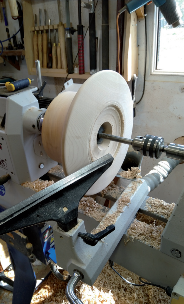 Wood being turned on a lathe in workshop.