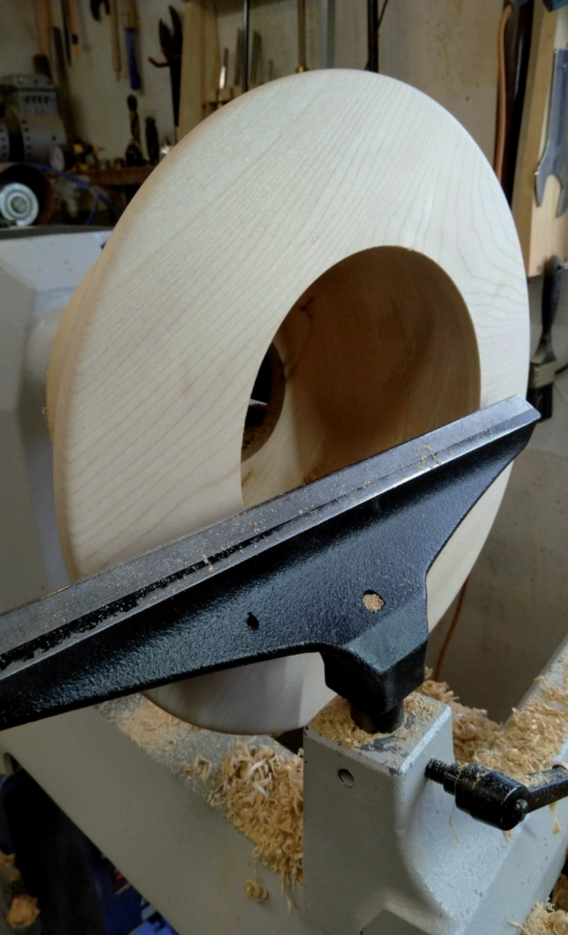 Wooden bowl being crafted on a lathe.