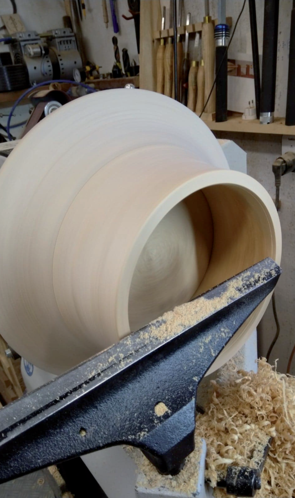Woodturning on a lathe in a workshop.