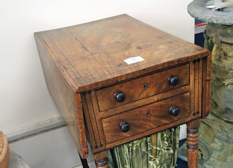 Antique wooden table with drawers and turned legs.