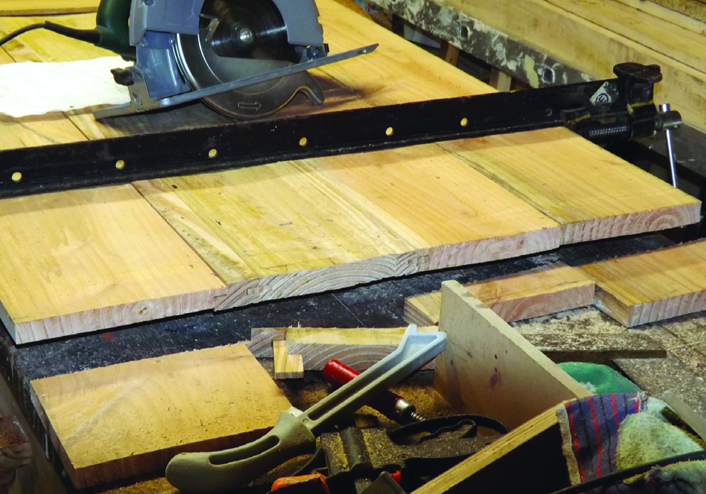 Table saw and timber on woodworking bench