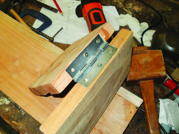 Woodworking hinge assembly on workbench.