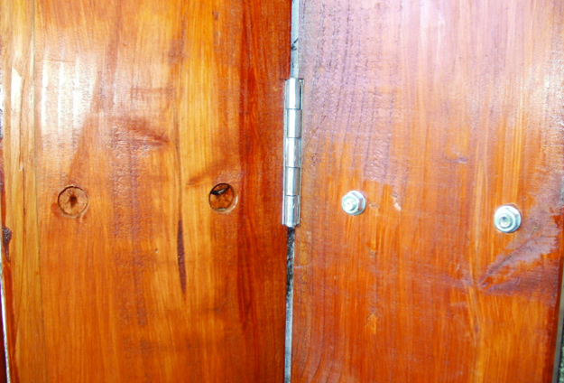 Wooden door hinge with visible screws