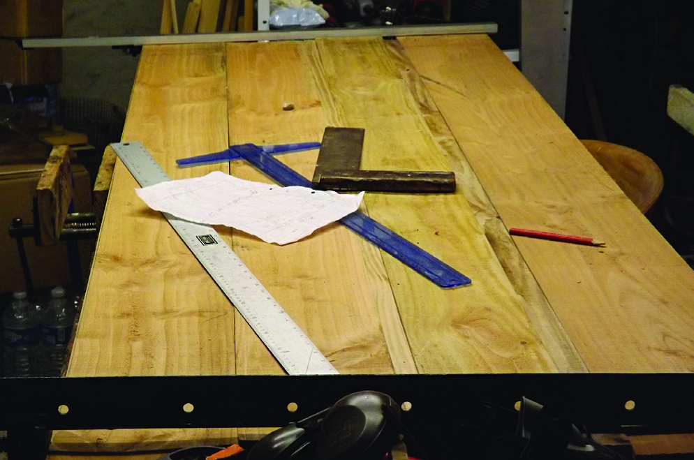 Carpentry tools and plans on wooden workbench.