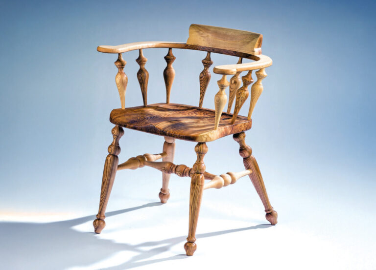 Classic wooden chair with curved armrests.