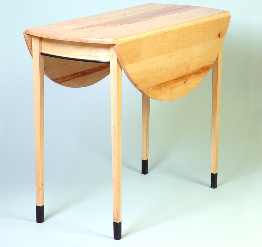 Wooden drop-leaf table with black accents.