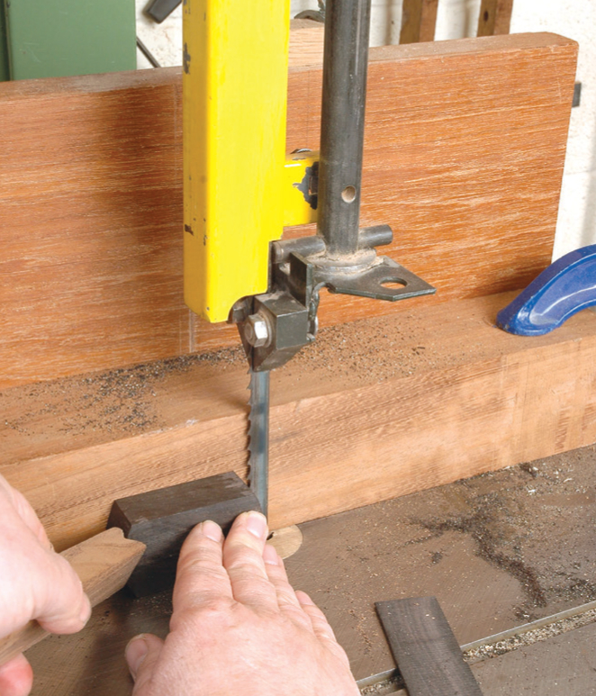 Using bandsaw to cut wooden plank safely.