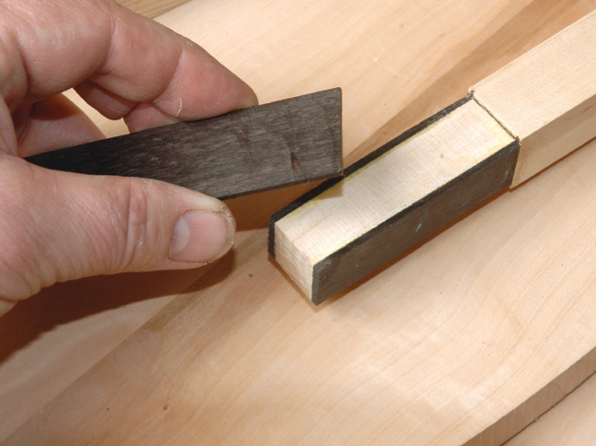 Hand showing wood dovetail joint example.