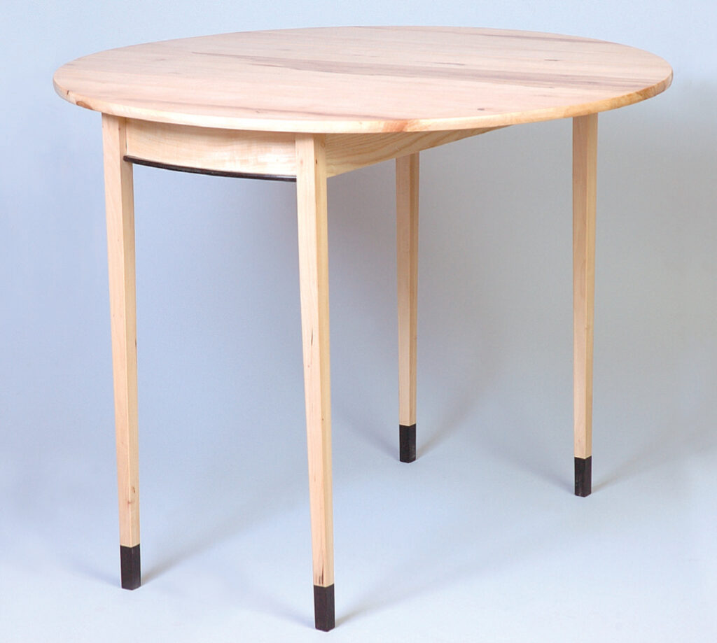 Round wooden table with dark leg tips