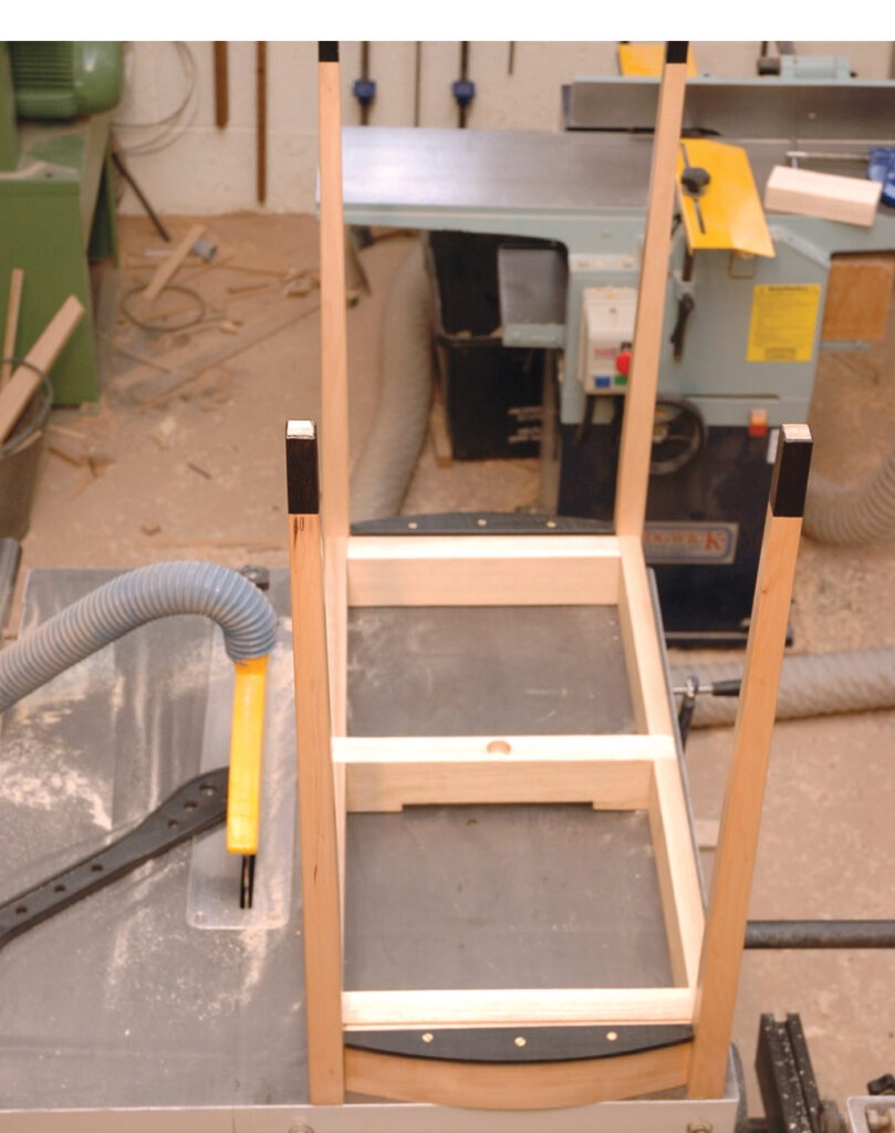 Wooden chair frame in workshop with tools.