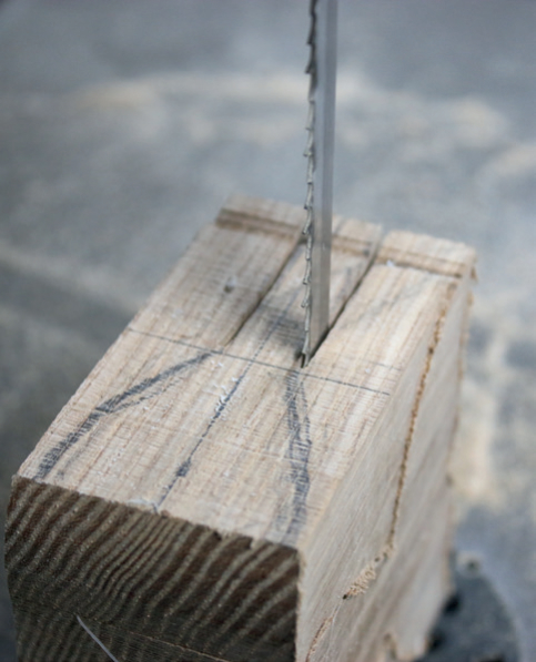 Close-up of saw cutting wood block.
