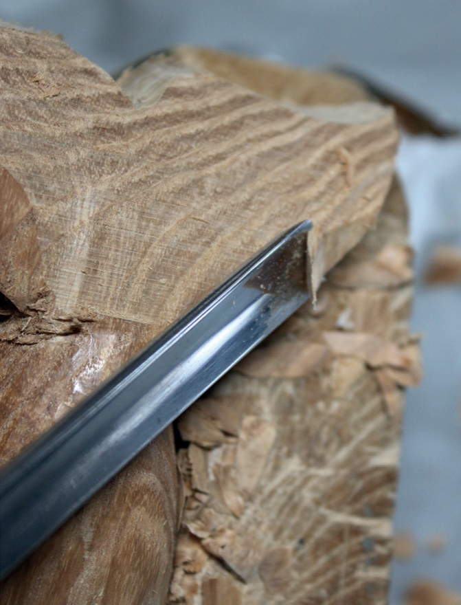 Close-up of wood carving with chisel tool.