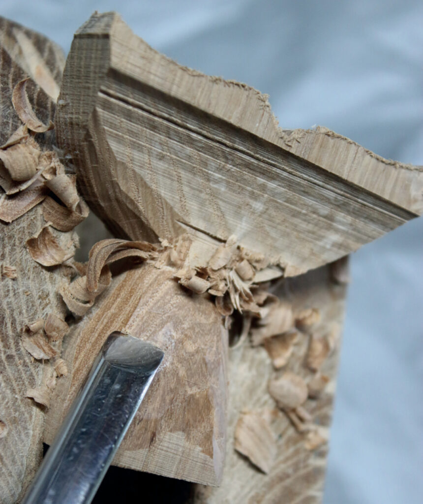 Wood carving detail with chisel and shavings.