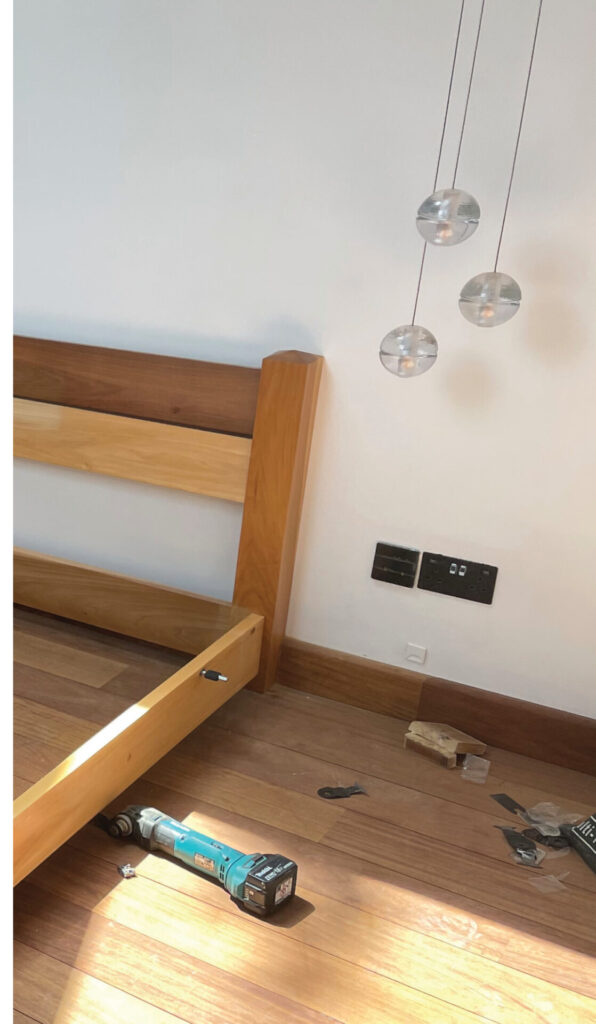 Bed assembly with tools on wooden floor.