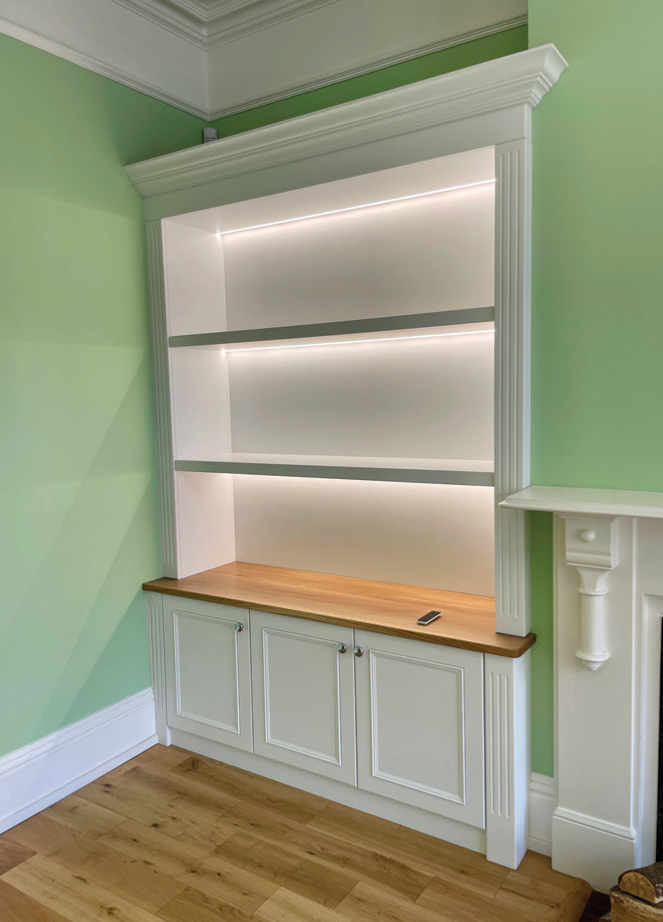 White built-in bookcase with LED lighting.