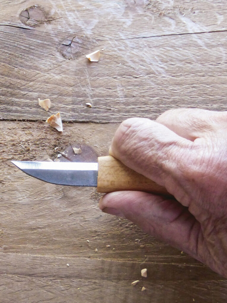 Hand carving wood with sharp knife