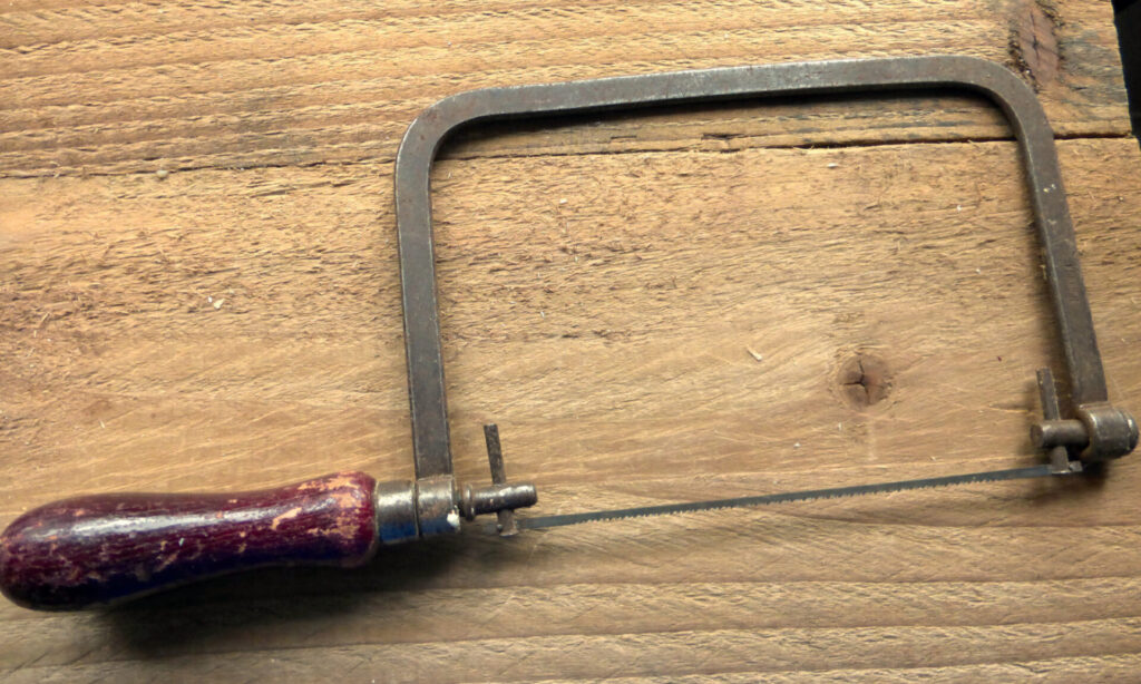 Vintage fretsaw on wooden workbench