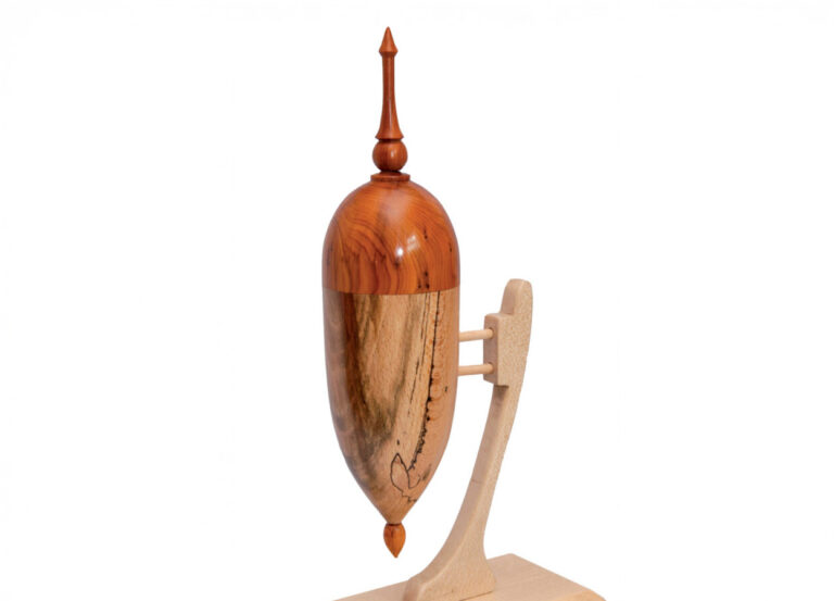 Wooden decorative finial on a display stand.