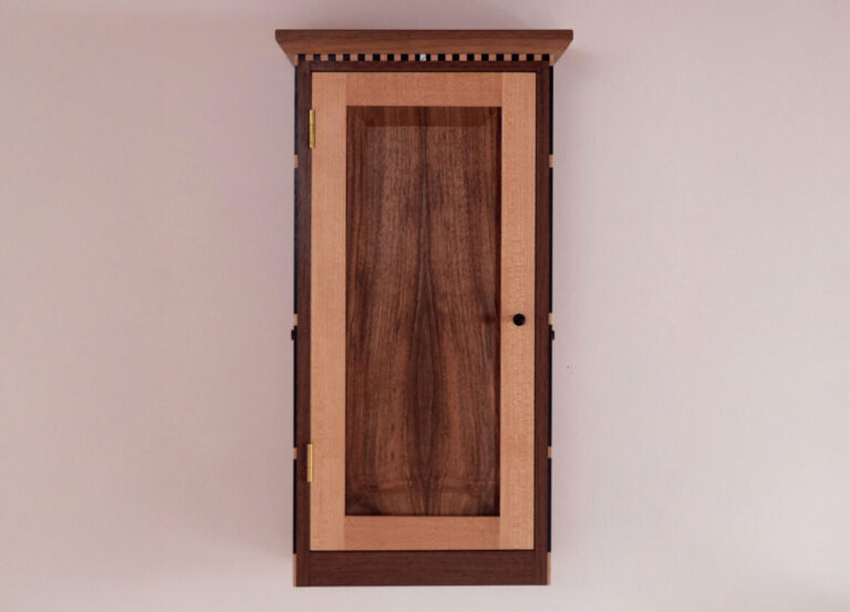 Wooden cabinet with detailed trim and door