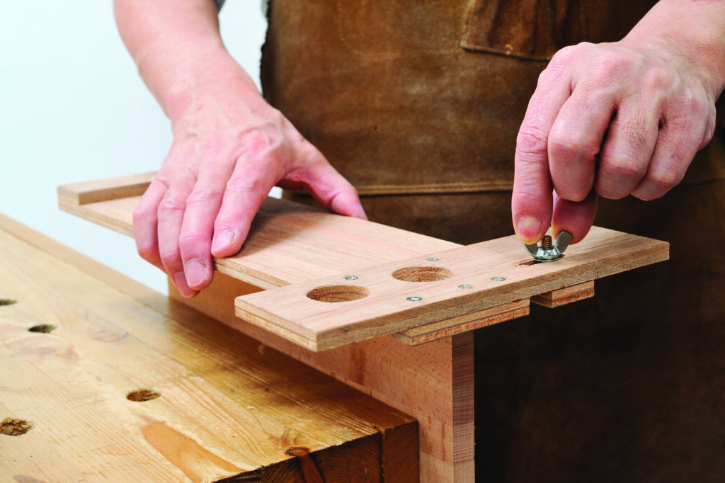 Carpenter adjusting wood with wing nut.