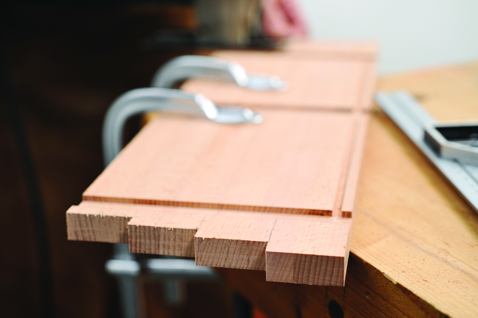 Wood pieces clamped on workbench for joinery project.