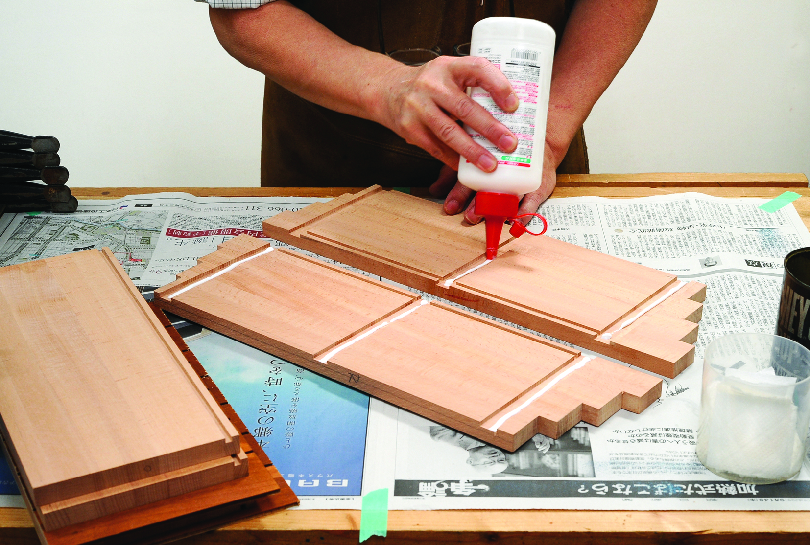 Applying glue to wooden boards for assembly.