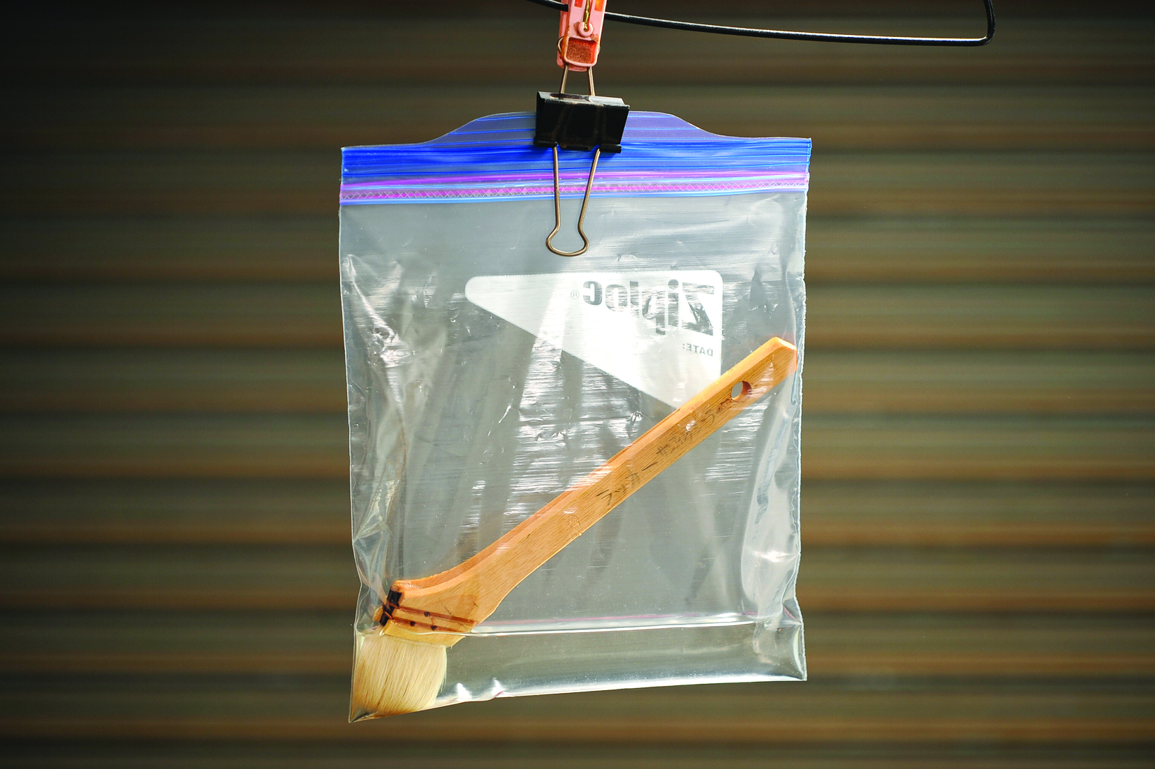 Paintbrush in sealed plastic bag hanging.