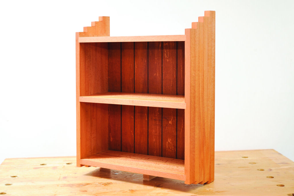 Wooden bookshelf with two shelves and stepped design.