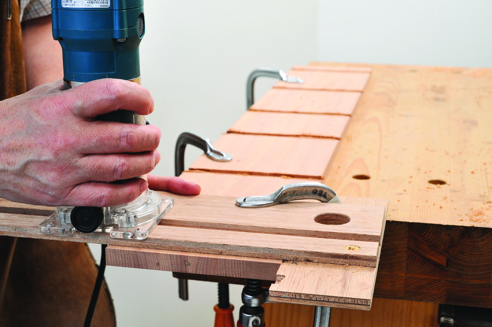 Person using router on wooden board