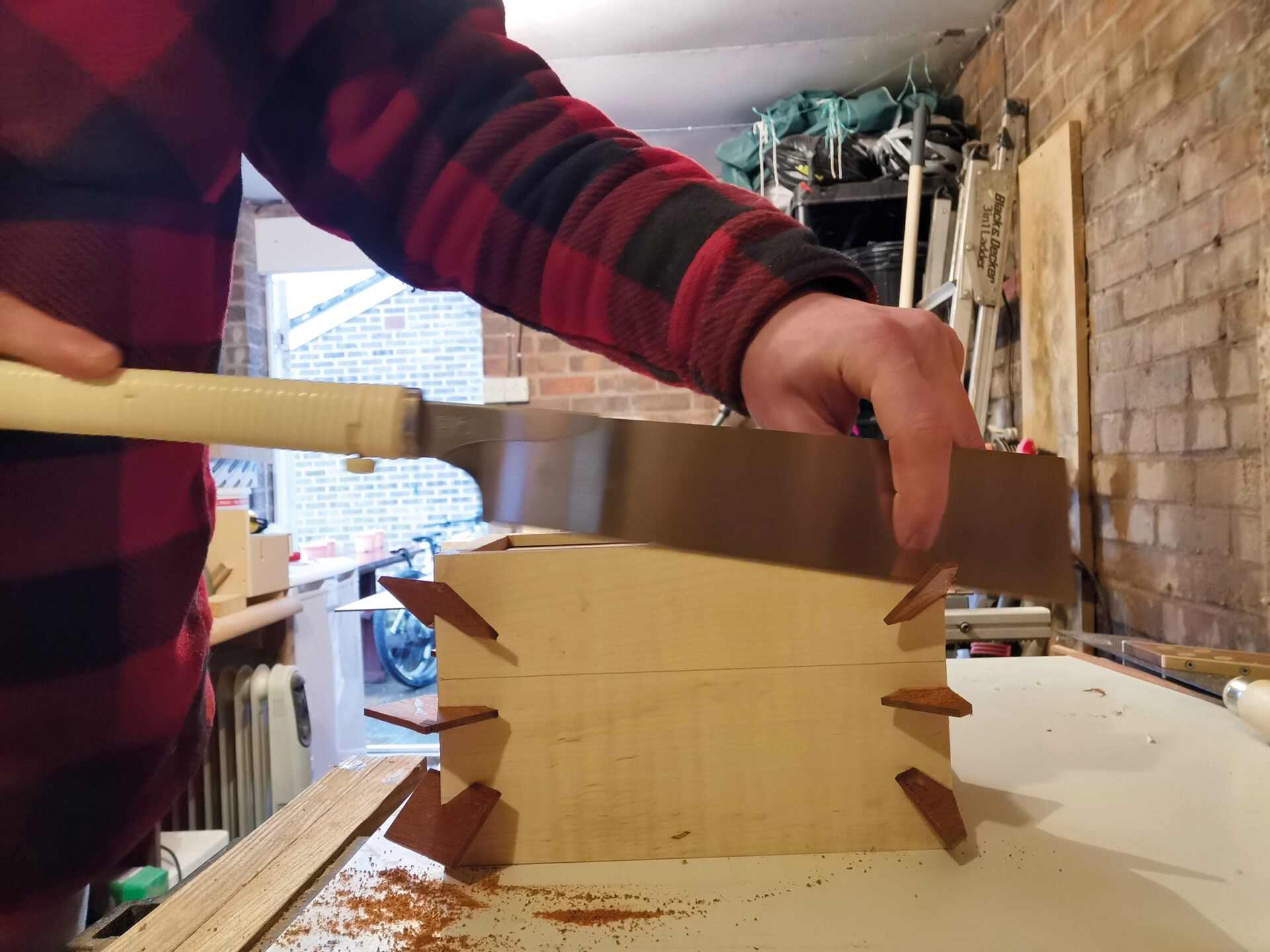 Sawing dovetail joints in woodworking project.