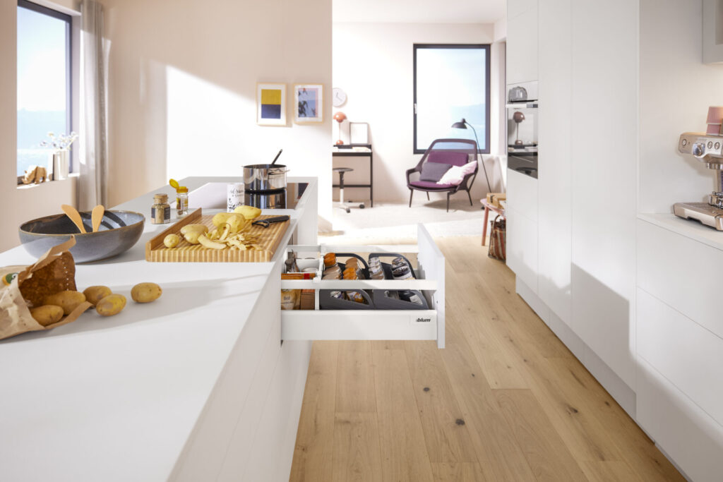 Modern kitchen with open drawers and cooking ingredients.