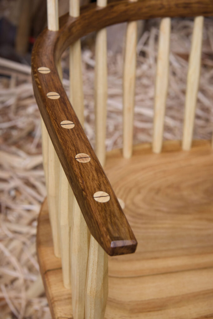 Close-up of wooden chair armrest with dowels.